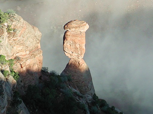 Balance Rock with fog rolling in under it, at the Colorado National Monument